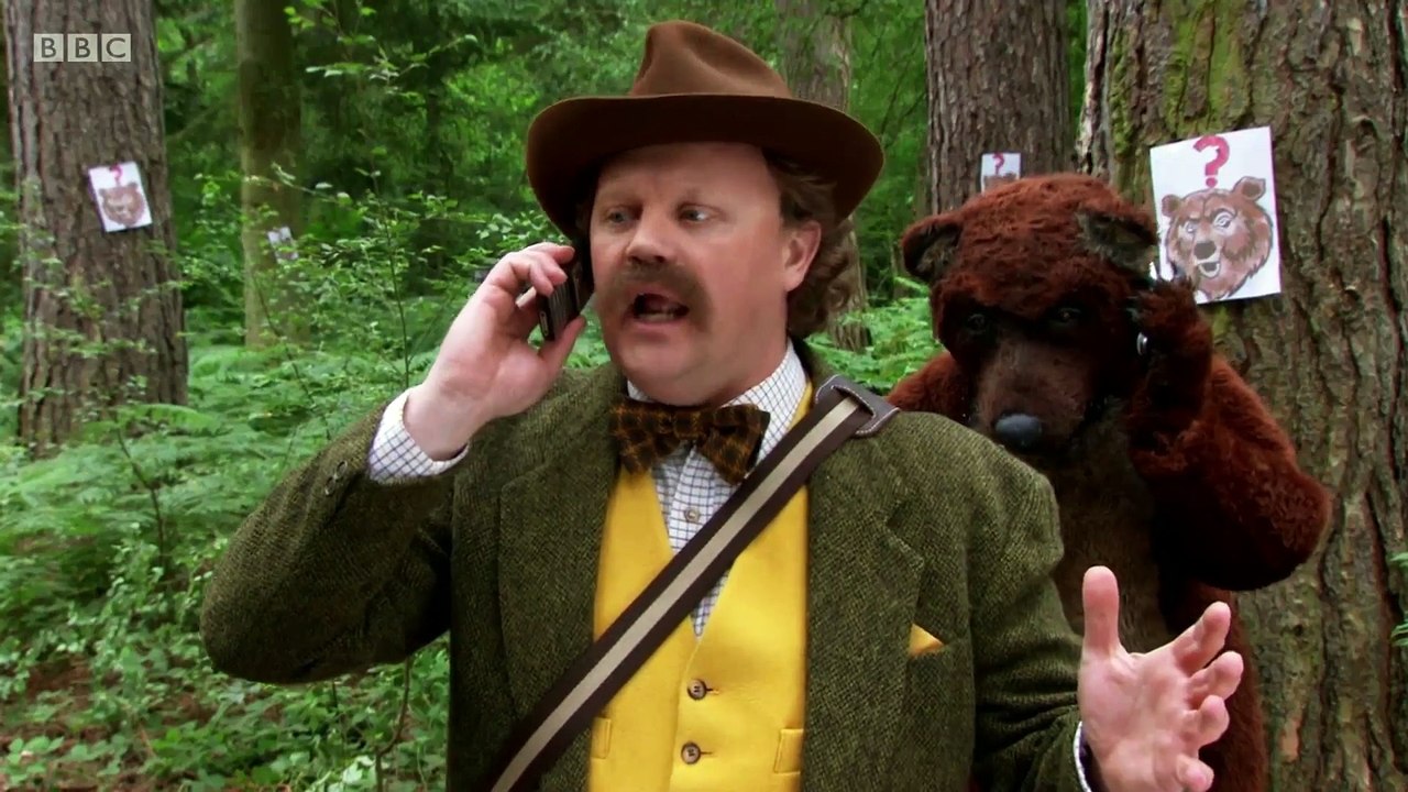 Gigglebiz Rapids Johnson searches for more bears in the woods using his mobile phone