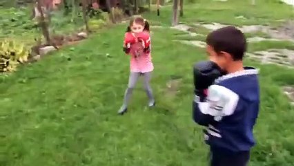 Une petite fille met une raclée à un garçon pendant un combat de boxe