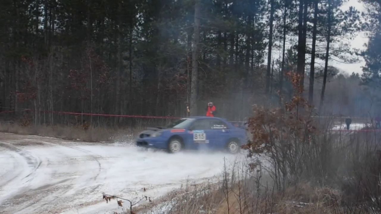 Un photographe placé à l'extérieur d'un virage (Rallye de Sno*Drift)