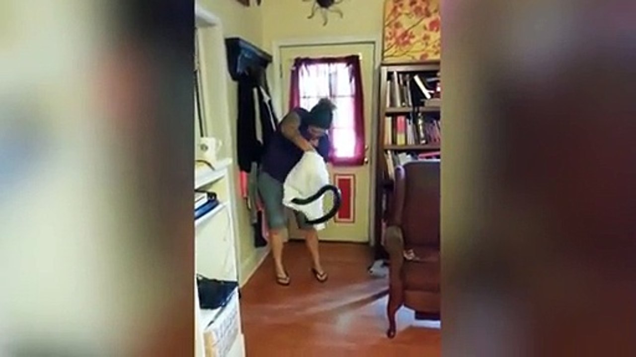 Señora captura a serpiente con funda de almohada