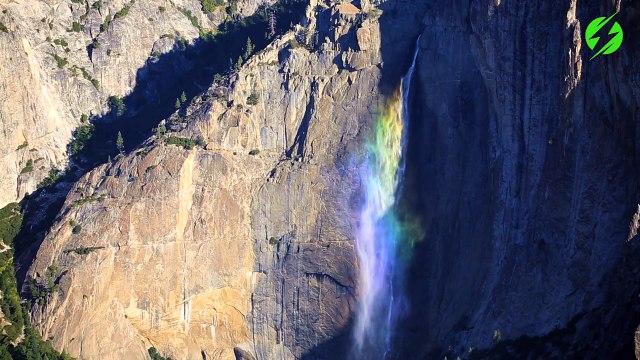 Cet arc-en-ciel se forme sur une chute d'eau en montagne ; magnifique