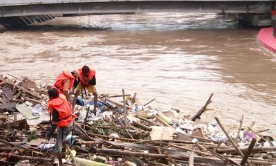 Petugas Bertaruh Nyawa Bersihkan Sampah Banjir