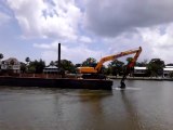 Cette barge avance grâce à une pelleteuse dans l'eau !