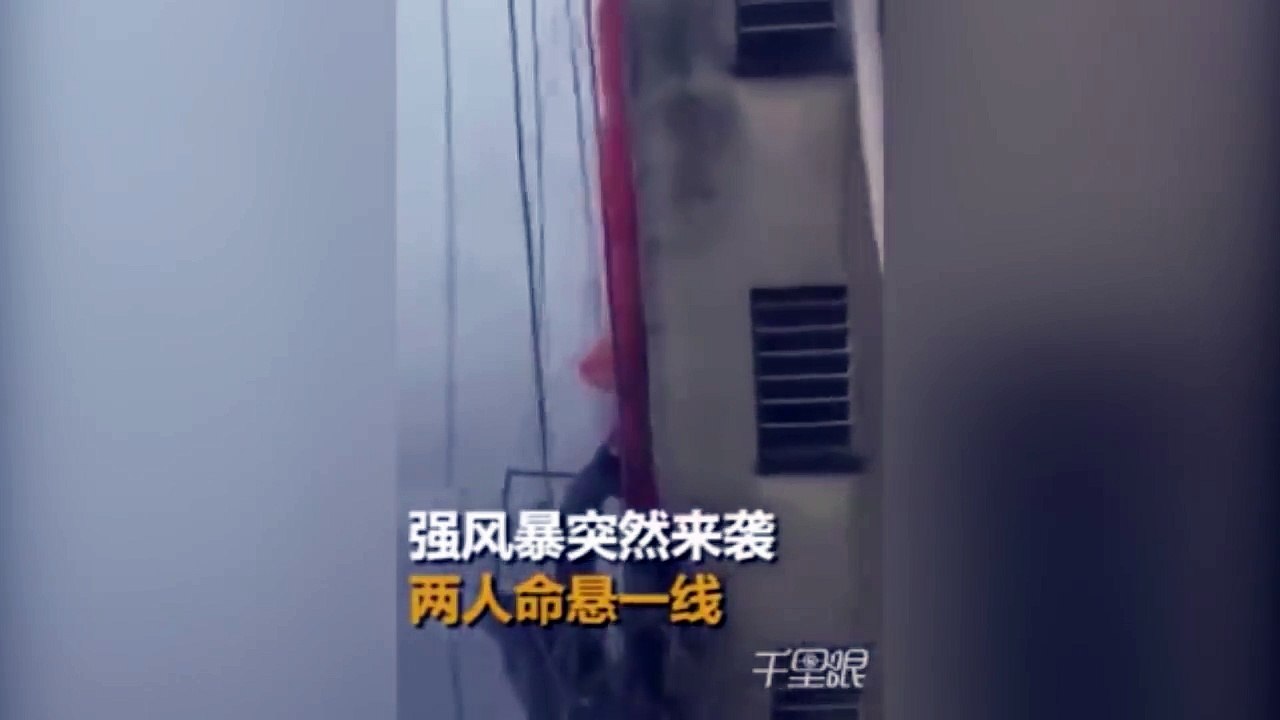 Des laveurs de vitres sur une nacelle sont pris dans une tempête (Chine)