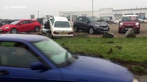 BMW leaves road and crashes into Mini on garage forecourt