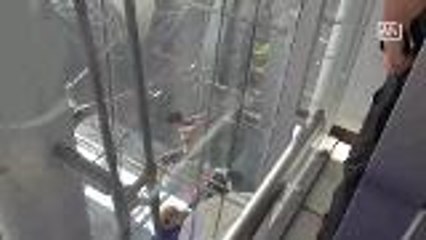 Woman dangles outside airport building; causes stir