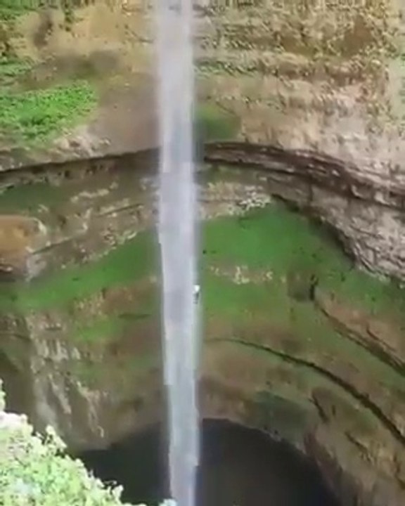 Vertigineux, il saute du haut de cette falaise le long d'une chute d'eau magnifique