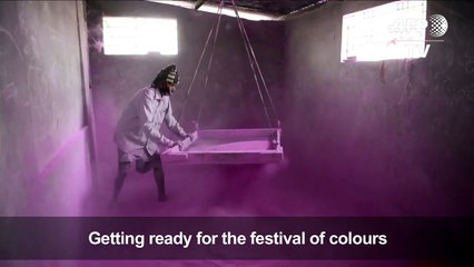 Indian workers prepare coloured powder for Holi festival