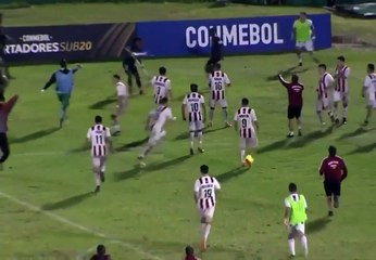 Poursuivi par des adversaires, un footballeur se défend avec le poteau de corner