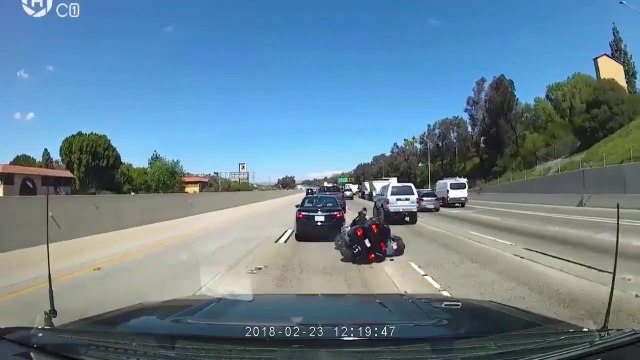 Ce motard a le réflexe de se jeter au sol pour éviter un voiture qui vient de freiner subitement