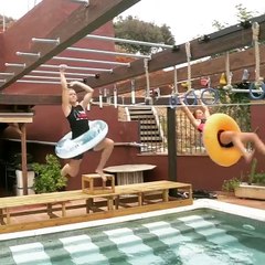 Two Girls Climb Monkey Bars Over Swimming Pool