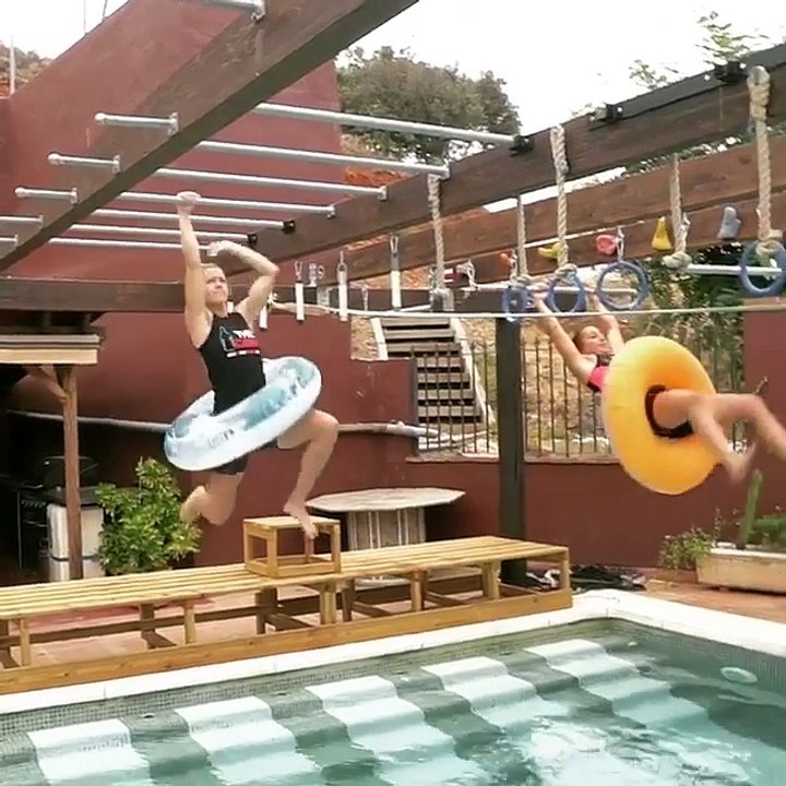 Two Girls Climb Monkey Bars Over Swimming Pool