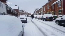 Man goes skiing down snow-covered road in England