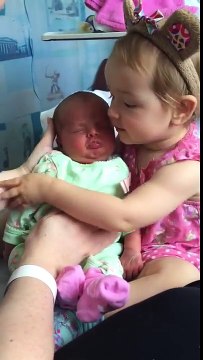 La tête de ce bébé dans les bras de sa petite soeur lol