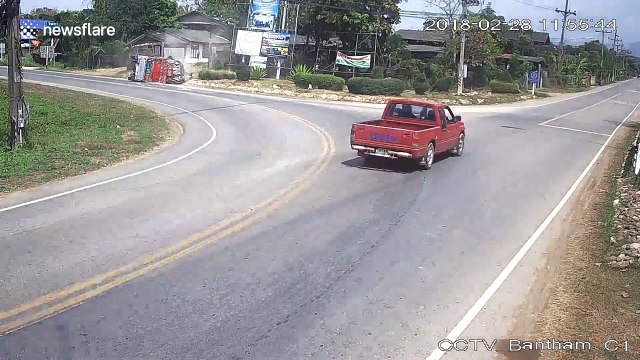 Truck overloaded with chickens topples over into path of motorcyclist