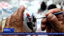 Skilled craftsman uses paint brush for Chinese New Year egg art
