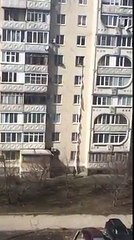 Une femme au 5eme étage noue des draps pour récupérer un colis