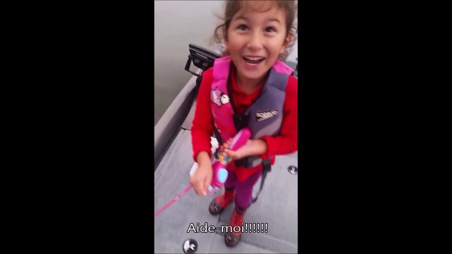 Cette fillette sort un beau poisson avec une canne à peche Barbie! La classe...