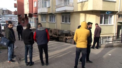 Kum yüklü kamyon apartmanın bahçesine devrildi
