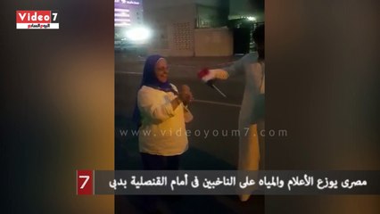 مصرى يوزع الأعلام والمياه على الناخبين فى أمام القنصلية بدبى