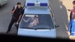 Une femme arretée par la police eclate le pare-brise de leur voiture à coup de pied