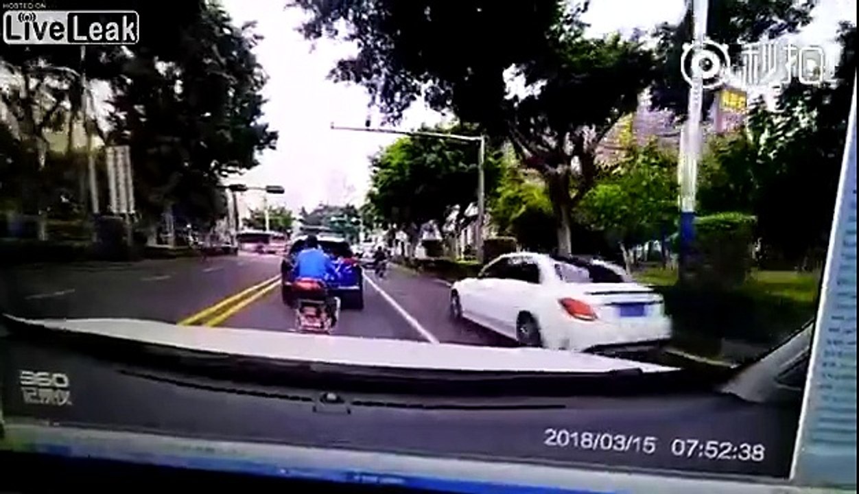 Man on a scooter brake checks a car and drives off. Driver chases and crashes into him