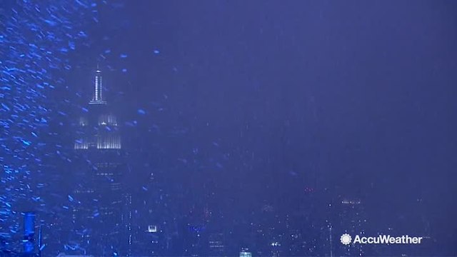City lights illuminate snowfall near Empire State Building