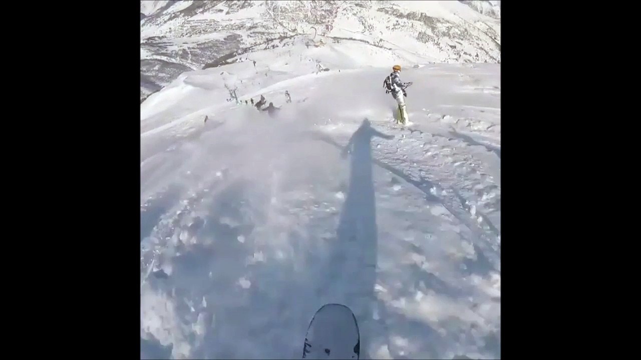 Ce snowbordeur s'amuse à balancer de la neige sur les skieurs aux tire-fesses..