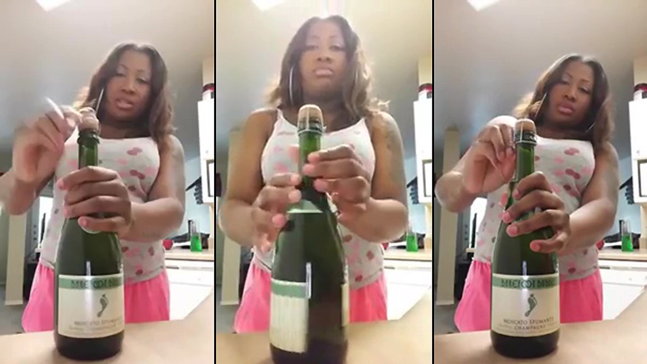 Une femme ouvre une bouteille de champagne