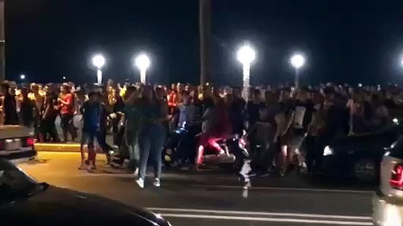 Una multitud persigue a una mujer en pantalones vaqueros y camiseta en Marruecos