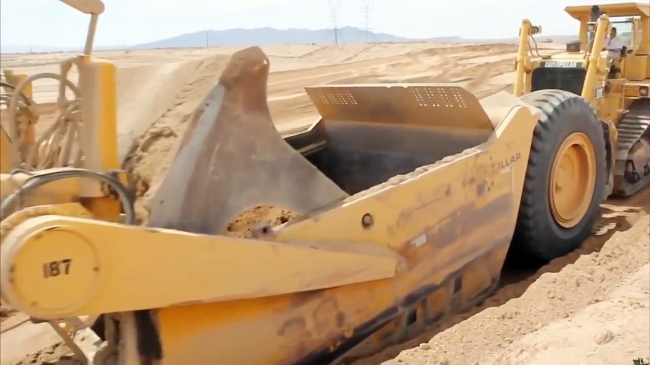 Дорожно-строительная техника, скрепер набирает землю