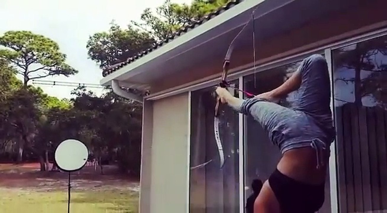 Tir à l'arc avec... ses pieds en faisant le poirier !