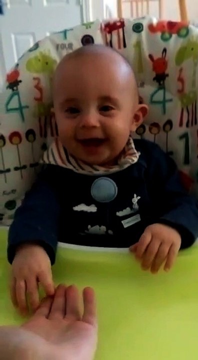 Cute baby laughing hysterically at mommy's hands