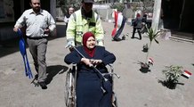 مسنة تدلي بصوتها على كرسي متحرك