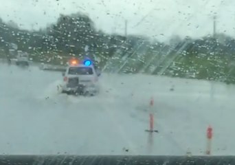 Police Escort Trucks through Floodwaters Near Ingham