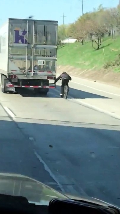 Cyclist Hitches Ride on Semi Truck on Highway