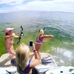 Deux femmes pêches avec des arcs à l'avant d'un bateau