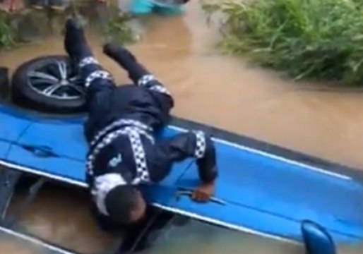 Fijian Police Smash Window of Car Partially Submerged by Floodwaters