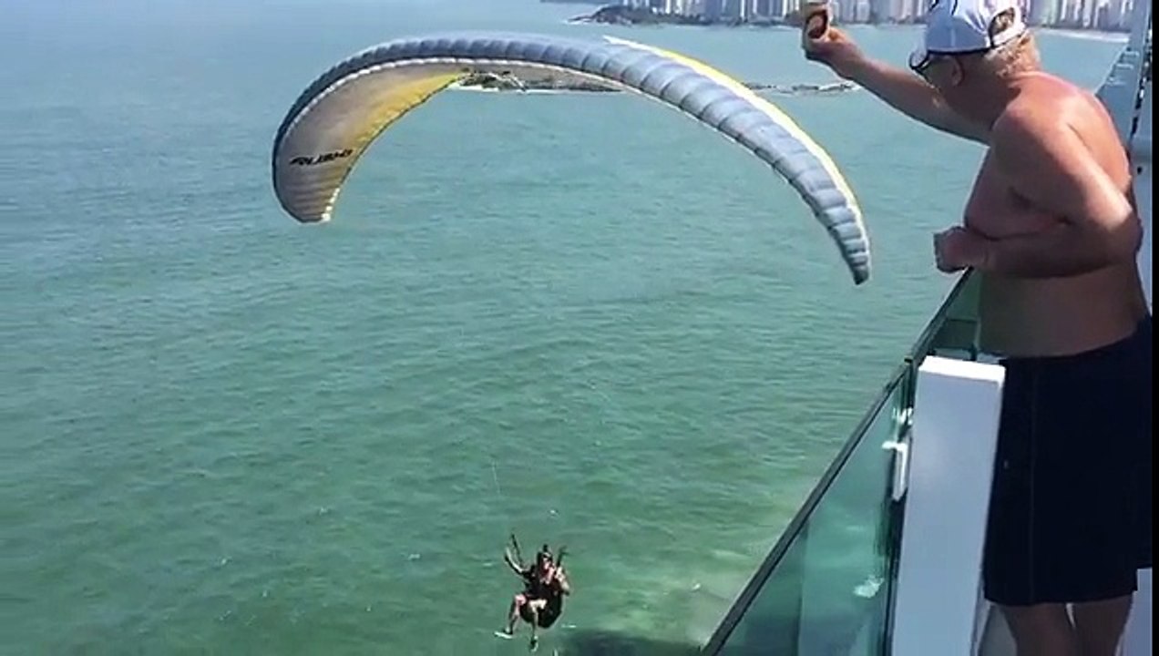 Un parapentiste attrape une bière depuis un balcon en plein vol