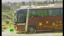 Autobuses con rebeldes sirios y sus familiares pasan por un punto de control ruso