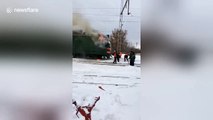 Only in Russia: Railway staff douse train blaze with snow