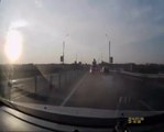 Un motard chanceux se retrouve debout sur le toit d'une voiture