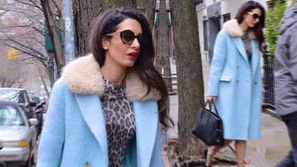 Amal Clooney oozes glamour in a leopard print dress and powder blue coat as she steps out in New York City.