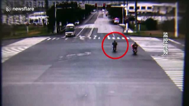 Scooter driver narrowly escapes being buried by lorry after running red light