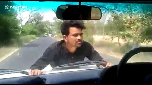 Angry protester clings to official's SUV bonnet for 4km