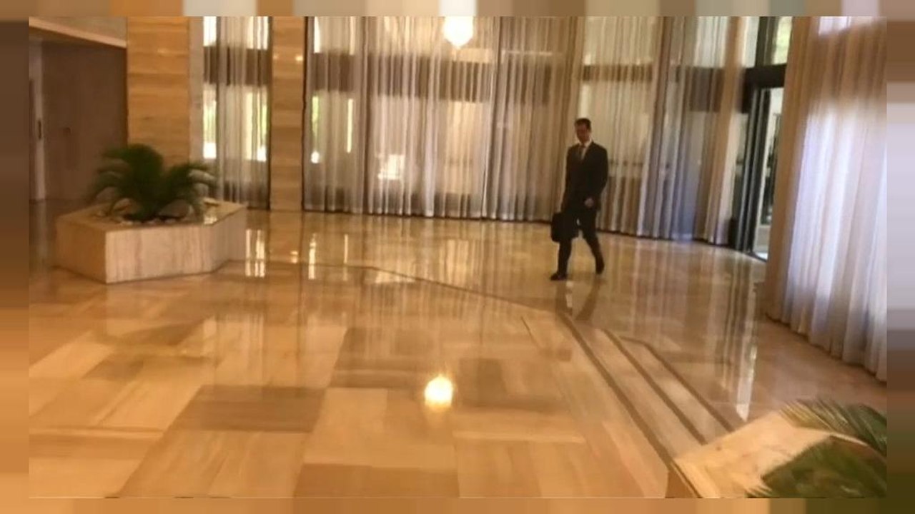 De mala na mão, o presidente sírio entrou tranquilamente no escritório