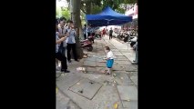 Çinli küçük çocuk, babasının dükkânını kapatmaya gelen polislere demir boruyla direndi!
