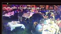 Un homme saute sur une table pour aider son pote pendant une bagarre dans un restaurant