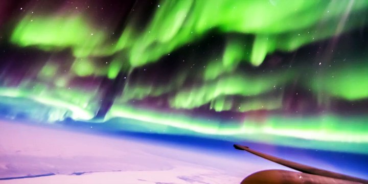 Un pilote davion vole à travers des aurores boréales