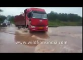 Bus drives onto flooded road and disappears into swirling waters!